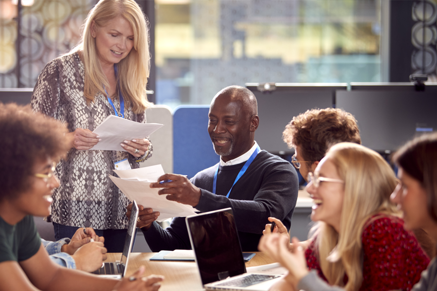 School administration sitting around table smiling while looking at data