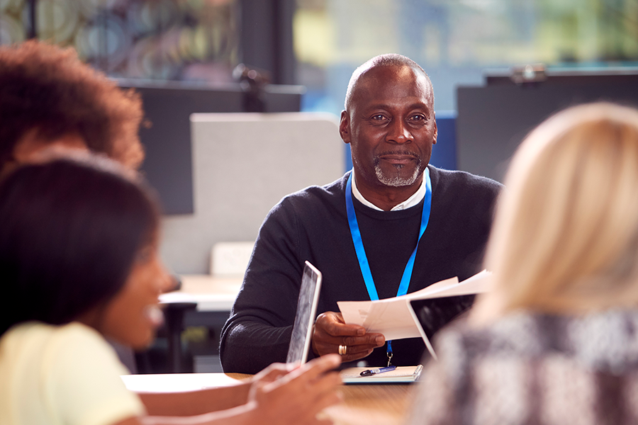 Man smiling in meeting with employees-1